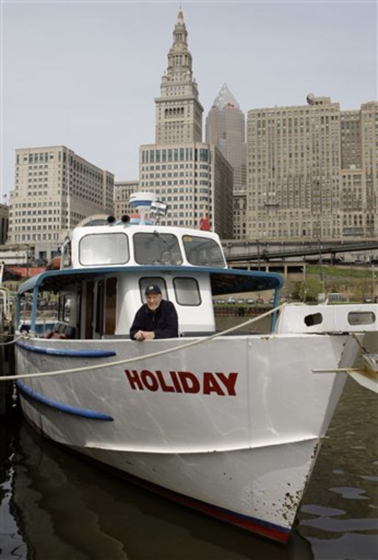 Wayne Bratton poses on his tour boat, \"Holiday\" docked on the Cuyahoga River in Cleveland Tuesday, April 20, 2010. (AP Photo/Mark Duncan)